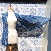 indigo handwoven cotton scarf draped on a mannequin, blowing in the wind