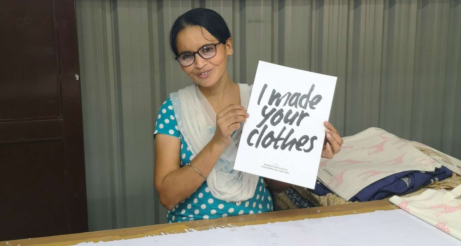 Pooja holding an I made your clothes sign